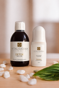 Detox Swiss Cure and Vitalislim Roll-On Anti-Cellulite with white pebbles and a leaf